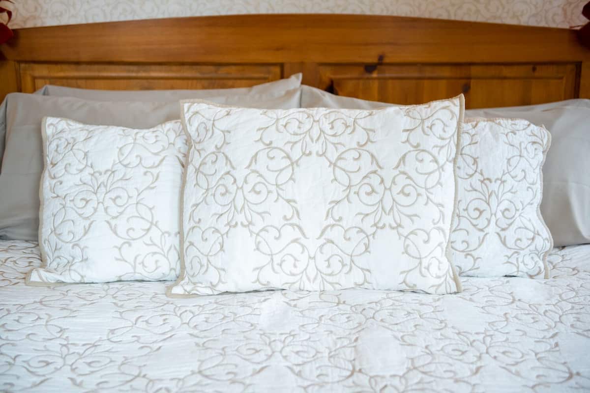 A bed with a wooden headboard and patterned bedding.
