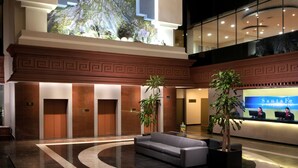 A lobby with a large mural of a mountain, a reception desk, and a seating area. - Krystal Monterrey (Monterrey)