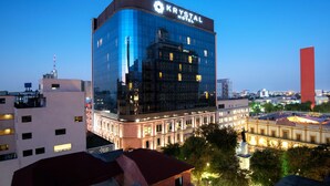 A modern hotel with a glass facade, named "KRYSTAL HOTEL," featuring a classic architectural style with a prominent statue in front. - Krystal Monterrey (Monterrey)