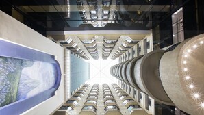 A high-rise building with a central atrium, multiple balconies, and a large, circular structure with lights. - Krystal Monterrey (Monterrey)