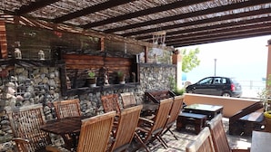 Un patio al aire libre con mobiliario de madera y una pared de piedra.