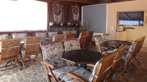 Un comedor con muebles de madera, una mesa redonda y un televisor montado en la pared.