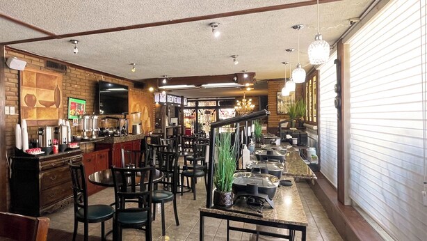A restaurant with a bar area, multiple seating arrangements, and a counter with various items. - Autel Rio Inn Luxury Inns (Piedras Negras)