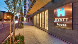 A modern hotel exterior with a prominent 'Hyatt House' sign, a well-lit sidewalk, and a tree-lined street. - Hyatt House Portland/Downtown (Portland)