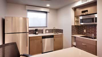 Una cocina moderna con electrodomésticos de acero inoxidable, lavavajillas y microondas.