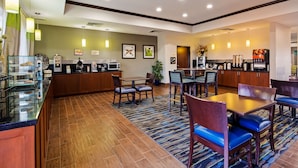 Un hall de hotel con comedor, cocina y recepción.
