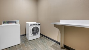 A laundry room with a washing machine, dryer, and a sink. - Best Western Plus Big Lake Inn (Big Lake)