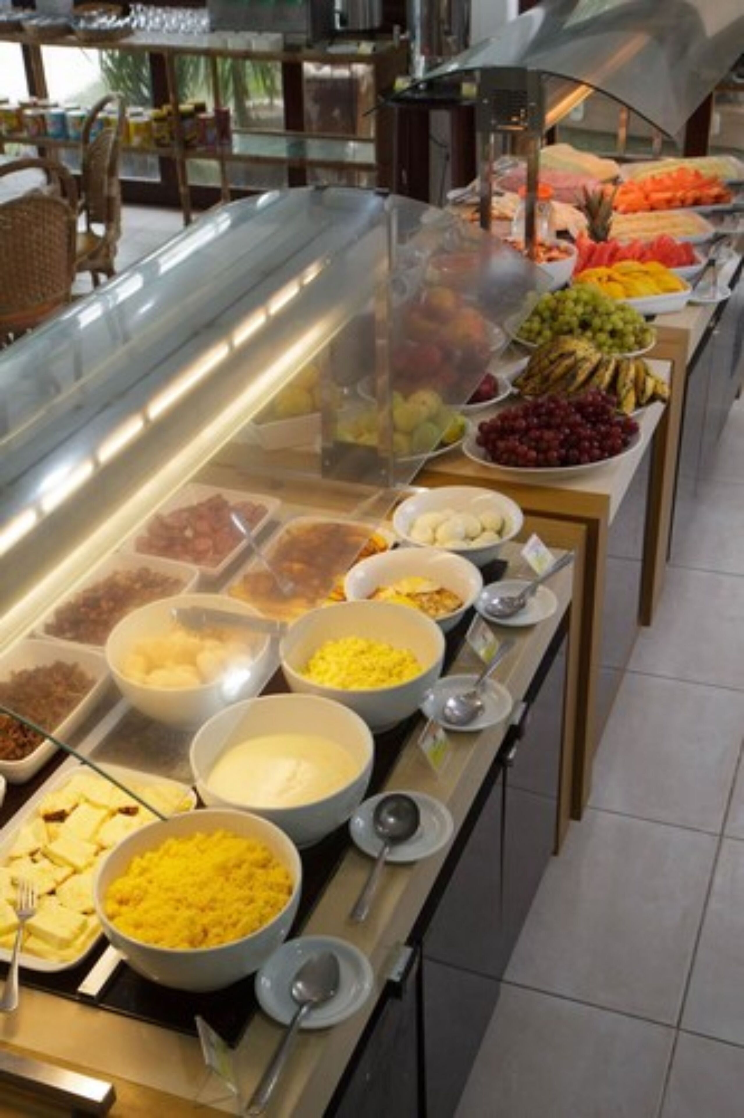 A buffet with various food items including fruits, vegetables, and prepared dishes.