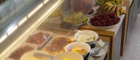 A buffet with various food items including fruits, vegetables, and prepared dishes.