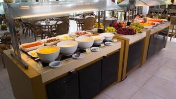 Montaje de bufé con diferentes alimentos y recipientes.