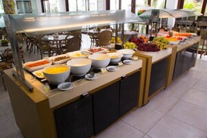 Montaje de bufé con diferentes alimentos y recipientes.