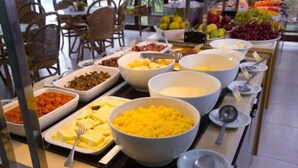 A buffet with various food items including rice, fruits, and vegetables. - Pousada dos Jangadeiros (Maragogi)