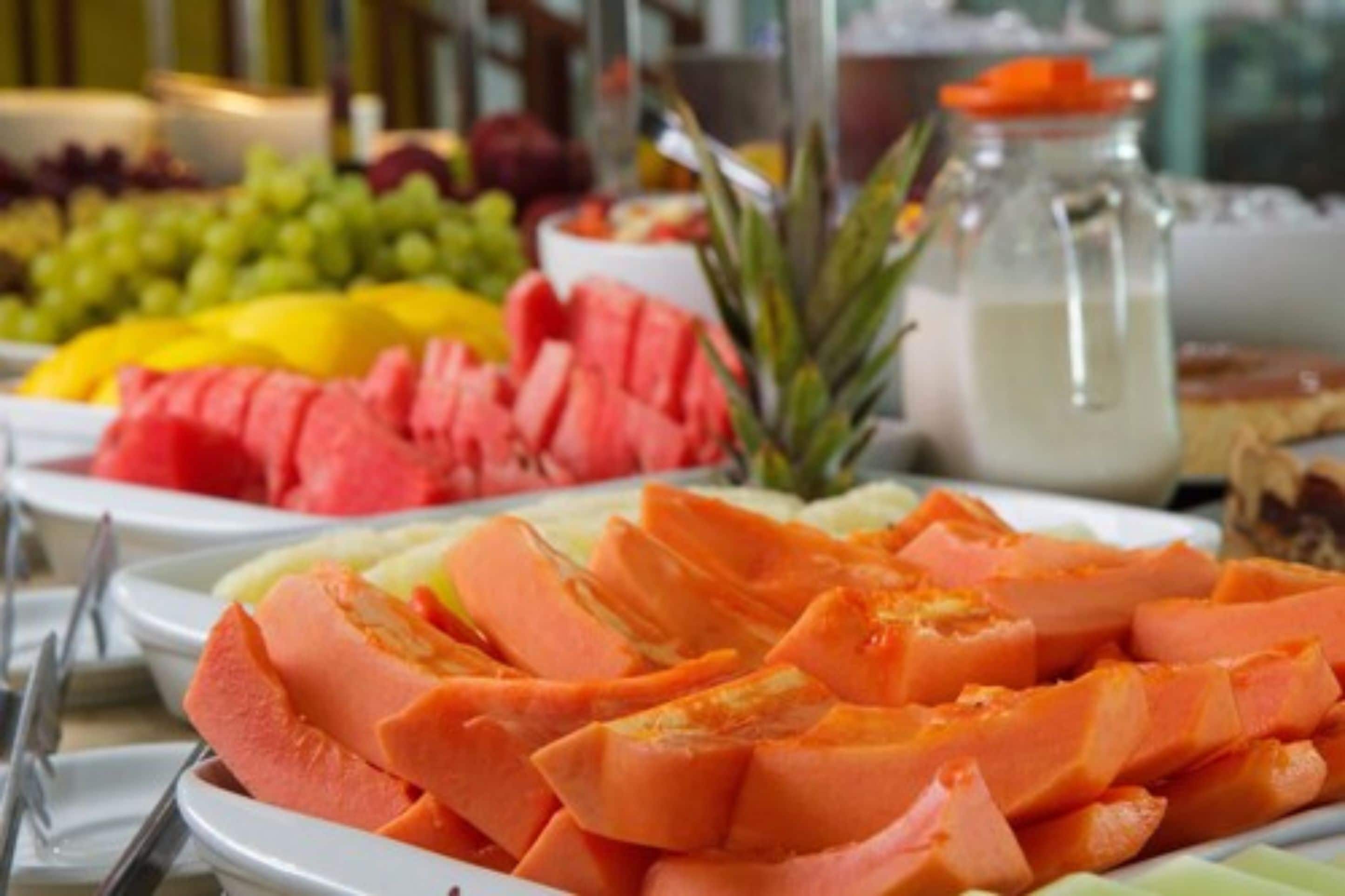 Ein reichhaltiges Buffet mit verschiedenen Früchten und einer Milchflasche.