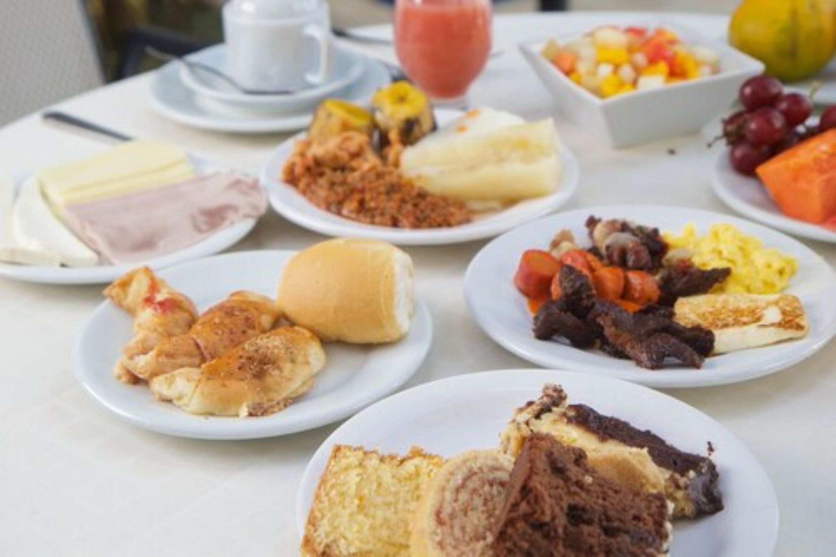 Un bufé de desayuno con diversos platillos, incluyendo huevos, carnes y pasteles.