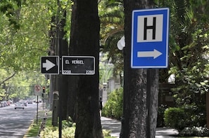 A street view with a hospital sign and a directional sign for El Vergel. - Hotel El Vergel (Santiago)