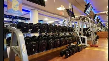 A gym with rows of dumbbells and exercise equipment.