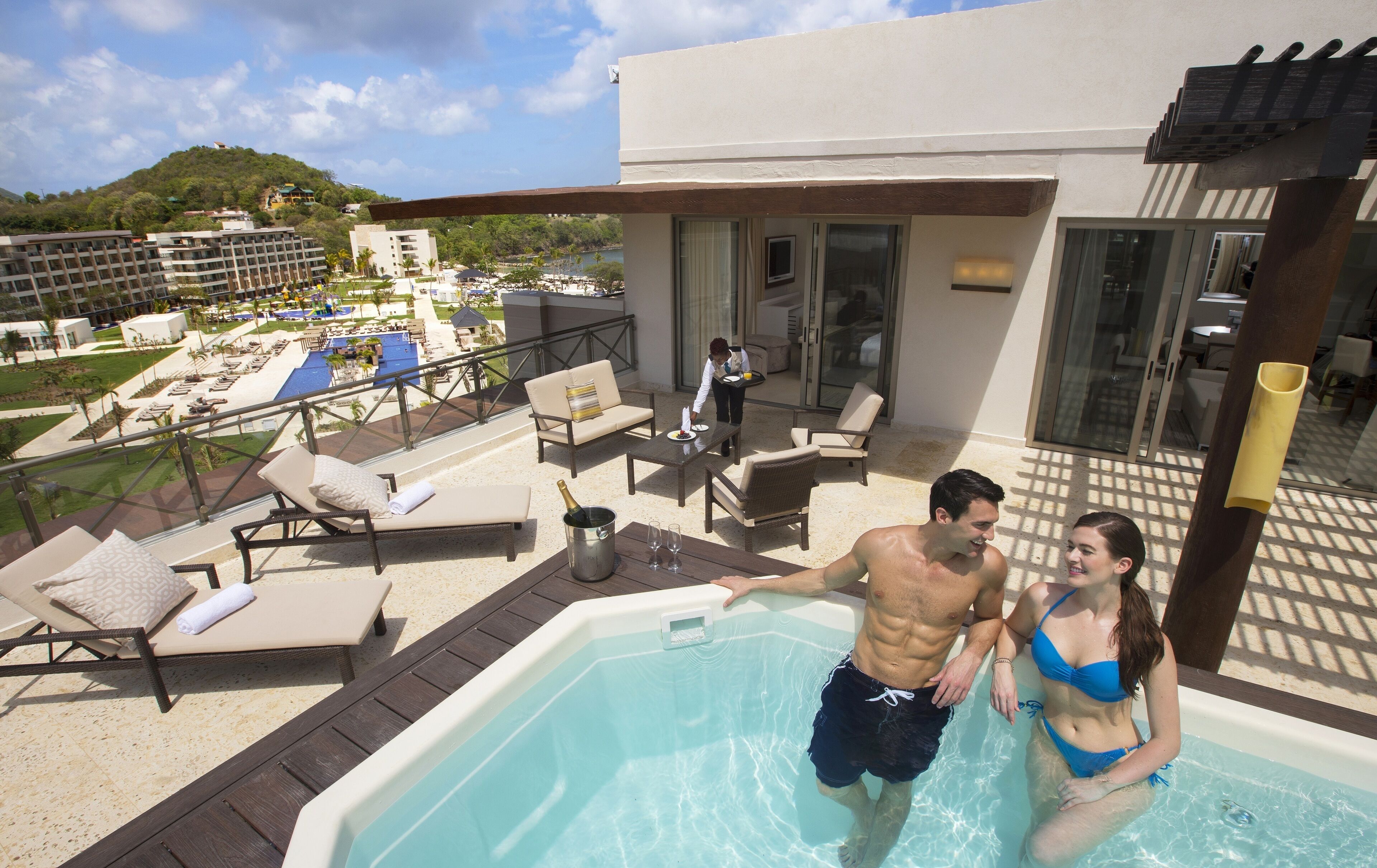 A pool area with lounge chairs, a hot tub, and a view of the resort's landscape.