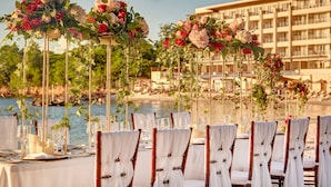 A beachfront dining setup with white tablecloths, bamboo chairs, and floral centerpieces. - Royalton Hideaway Saint Lucia, An Autograph Collection All-Inclusive Resort - Adults Only (Gros Islet)