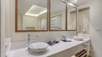Un baño moderno con dos lavamanos, un espejo grande y un perchero para toallas.
