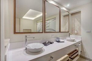Un baño moderno con dos lavamanos, un espejo grande y un perchero para toallas.