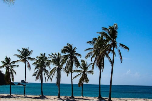 En la playa, playa de arena blanca, camastros y toallas de playa