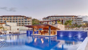 Un hôtel moderne doté d’une grande piscine, de nombreux balcons et d’un bar.