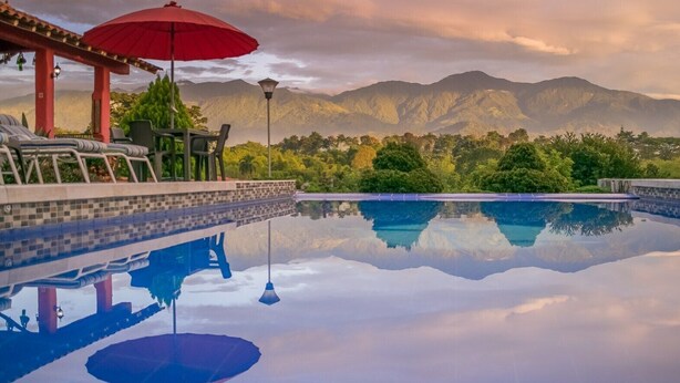 A serene pool area with a clear view of mountains in the background. - Hotel Campestre Solar De La Luna (Armenia)