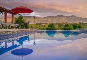 A serene pool area with a clear view of mountains in the background.