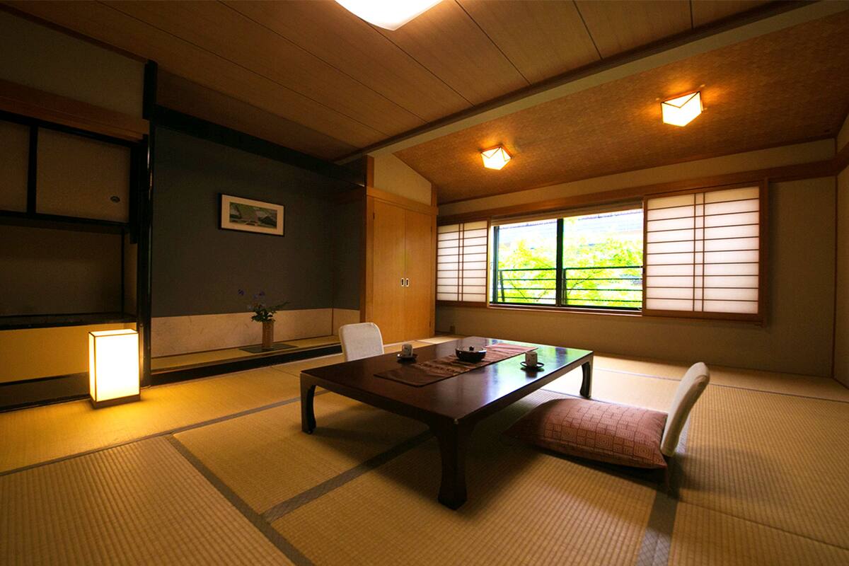 A traditional Japanese room with tatami flooring, a low table, and shoji screens.