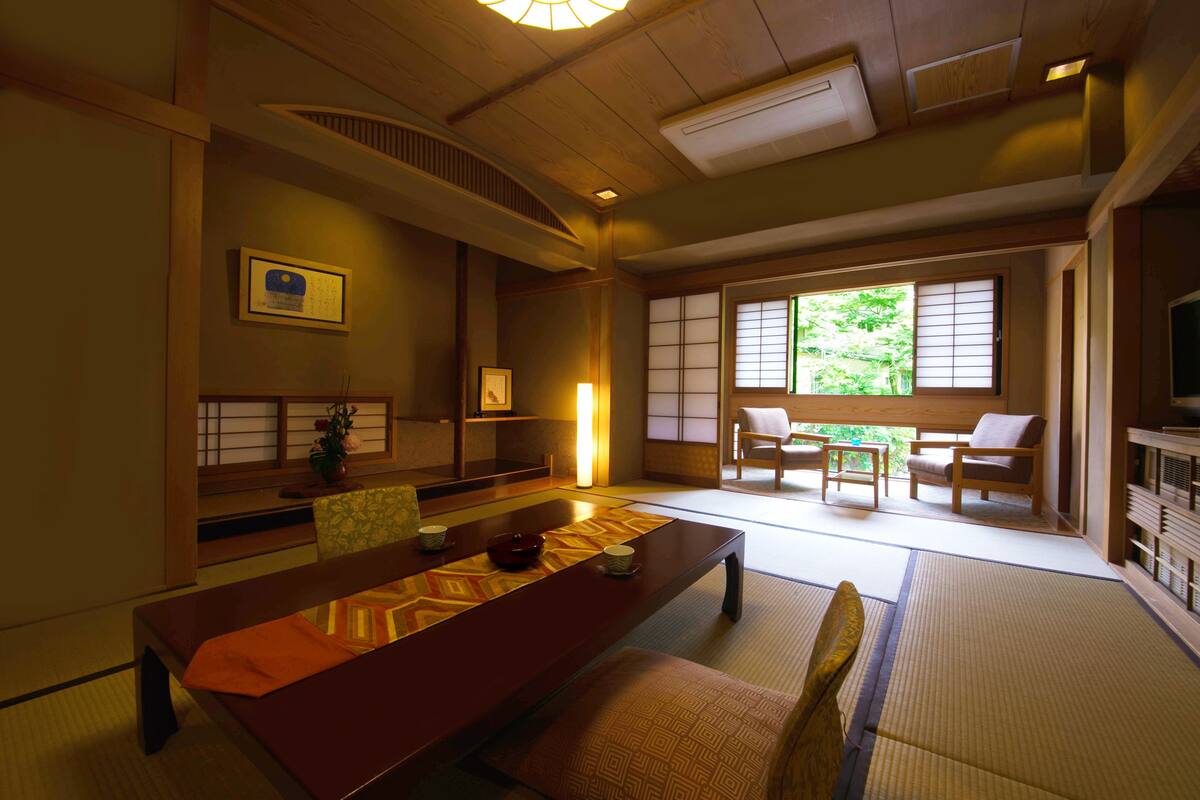 A traditional Japanese room with tatami flooring, a low table, and sliding doors.