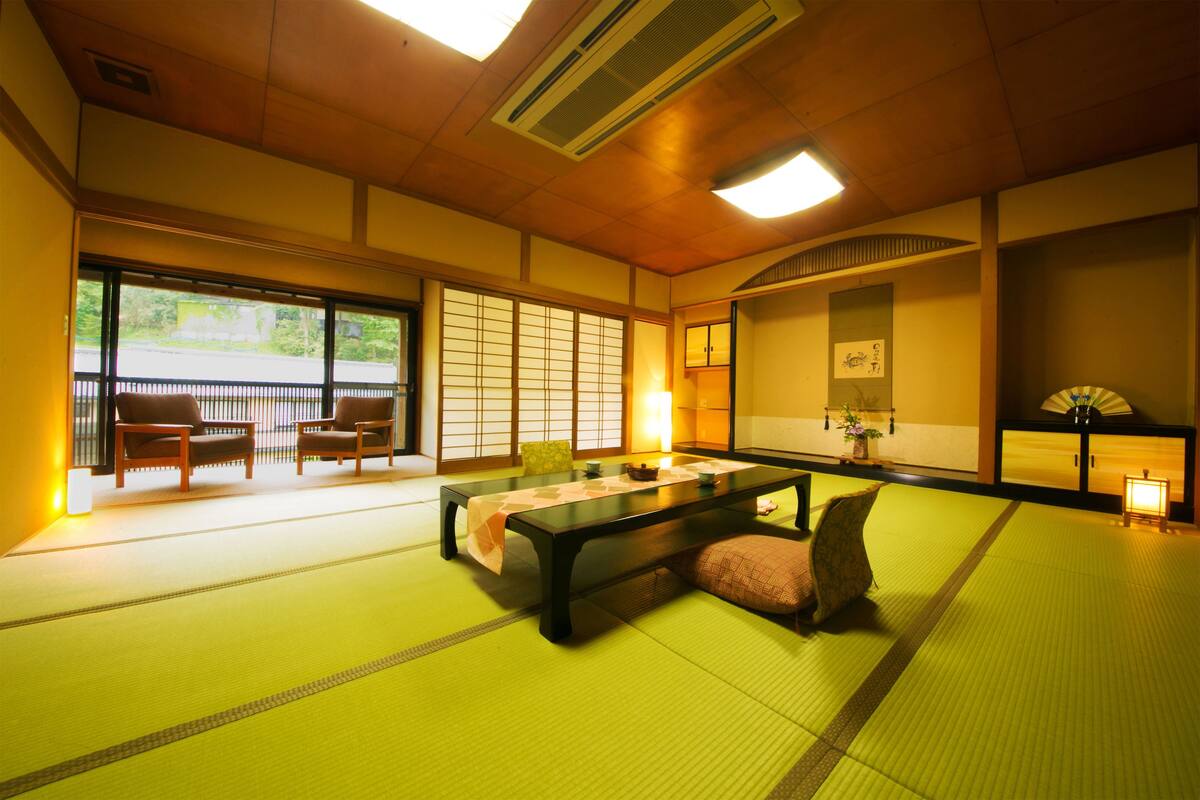 A traditional Japanese room with tatami flooring, a low table, and shoji screens.