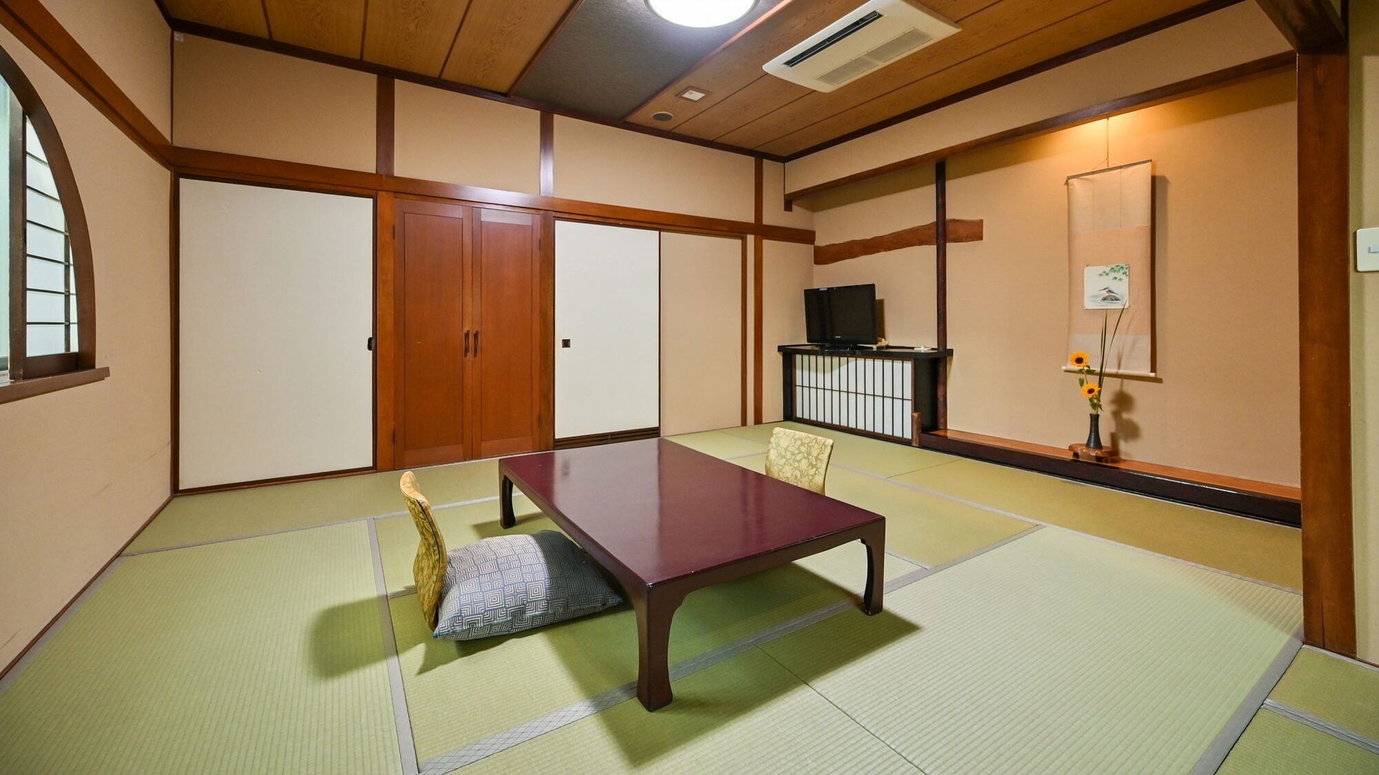 Una stanza con tatami, un tavolino basso, porte scorrevoli e un televisore.