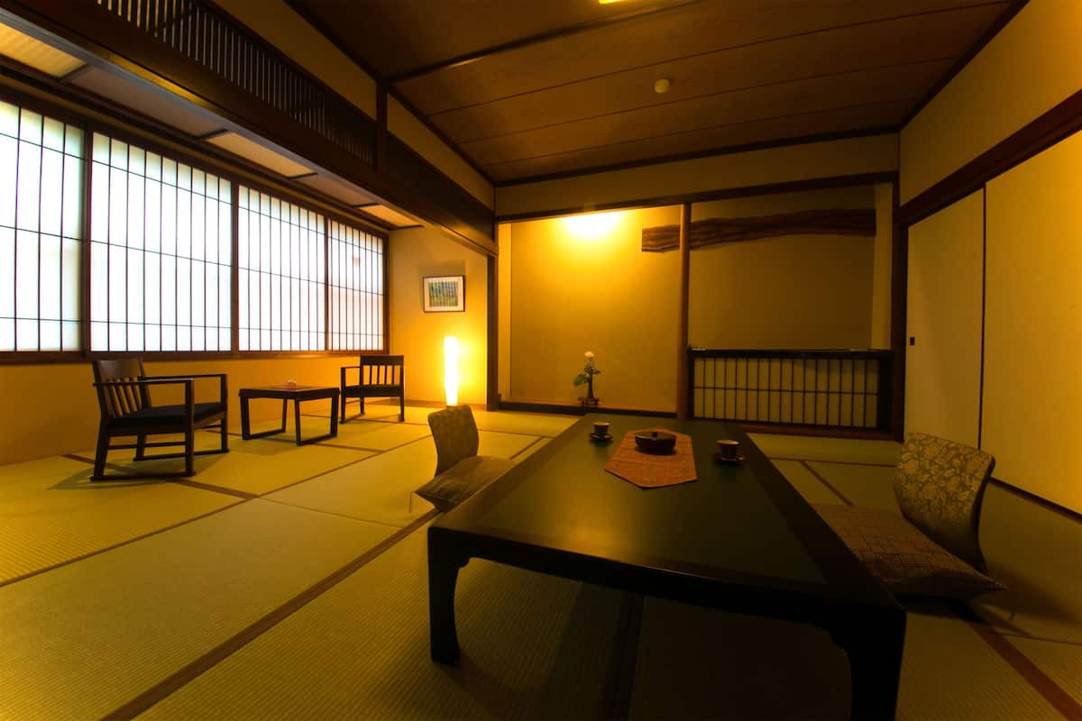 A traditional Japanese room with tatami flooring, a low table, and sliding doors.