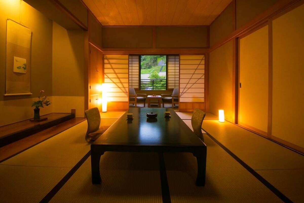 A traditional Japanese-style room with tatami flooring, a low table, and sliding doors.