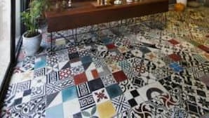 A lobby with a patterned floor, a reception desk, and a wall with a textured design. - Memory Hostel (Da Nang)