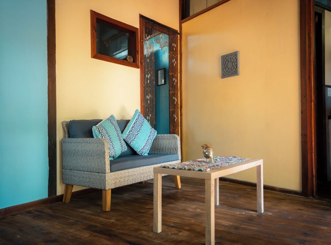 Una habitación con un sofá, una mesita y un panel decorativo en la pared.