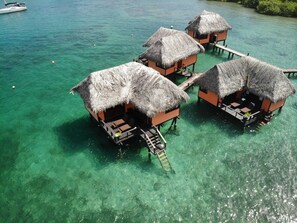Bungalows sobre el agua con techos de paja y senderos de madera.