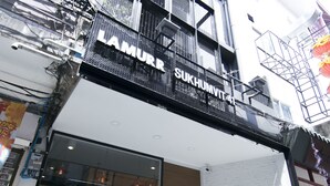 Ein Hotel mit moderner Fassade, großen Fenstern und einem Eingangsbereich mit Außenbestuhlung.