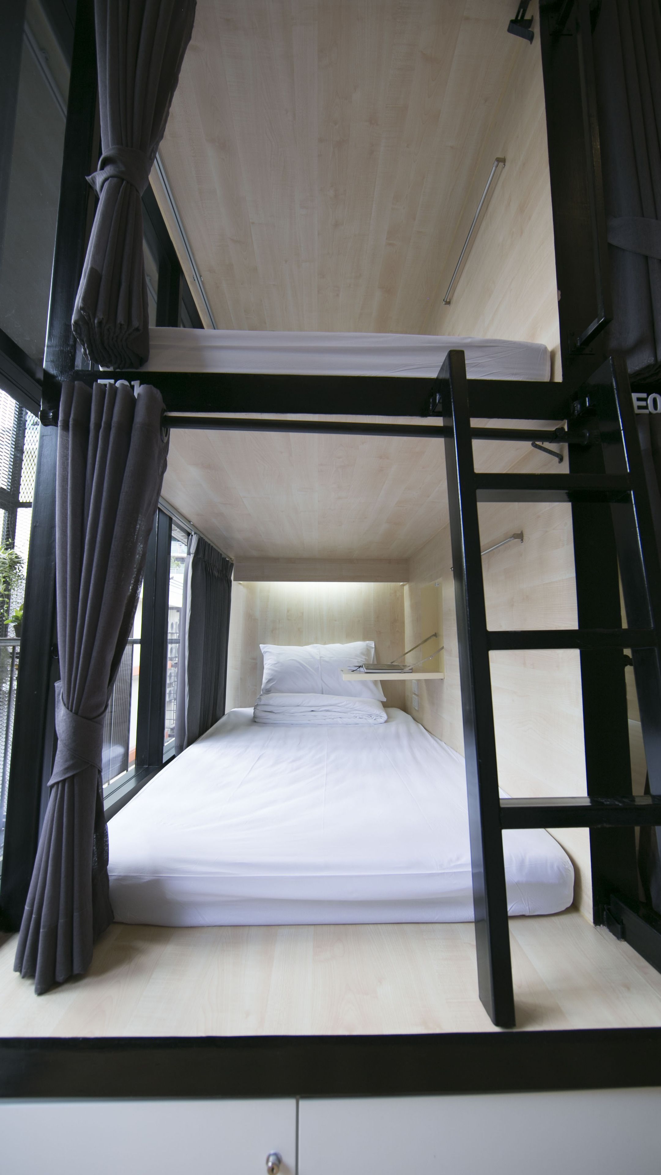 Ein Stockbett mit Holzunterbett und schwarzem Metallgestell.