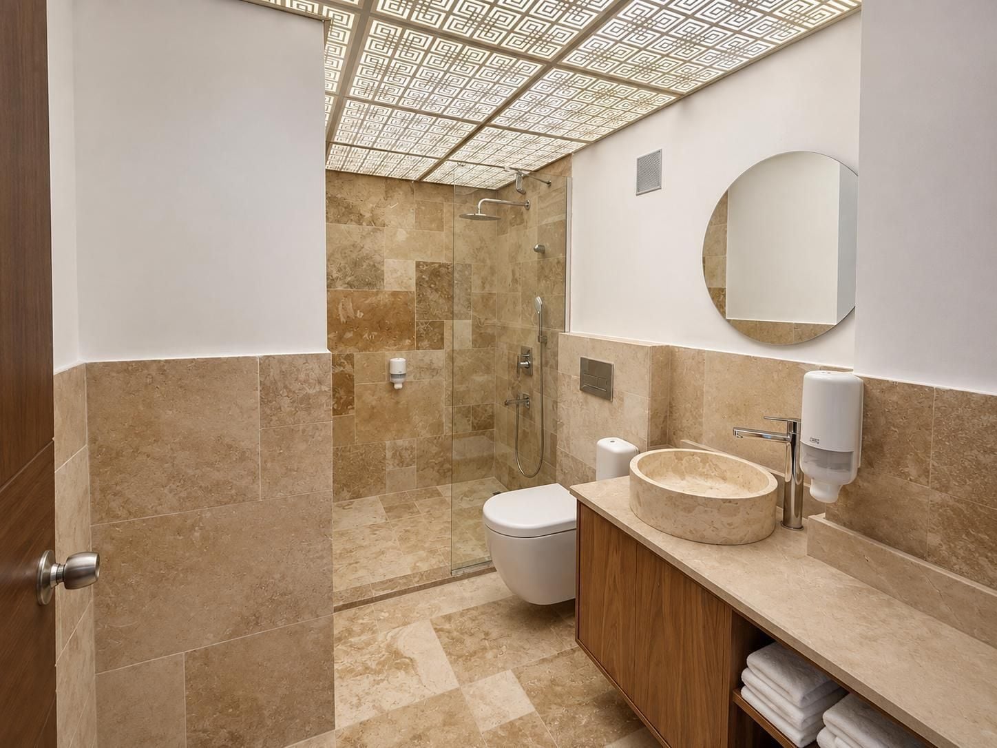 A modern bathroom with a glass-enclosed shower, a round sink with a marble basin, and a toilet.
