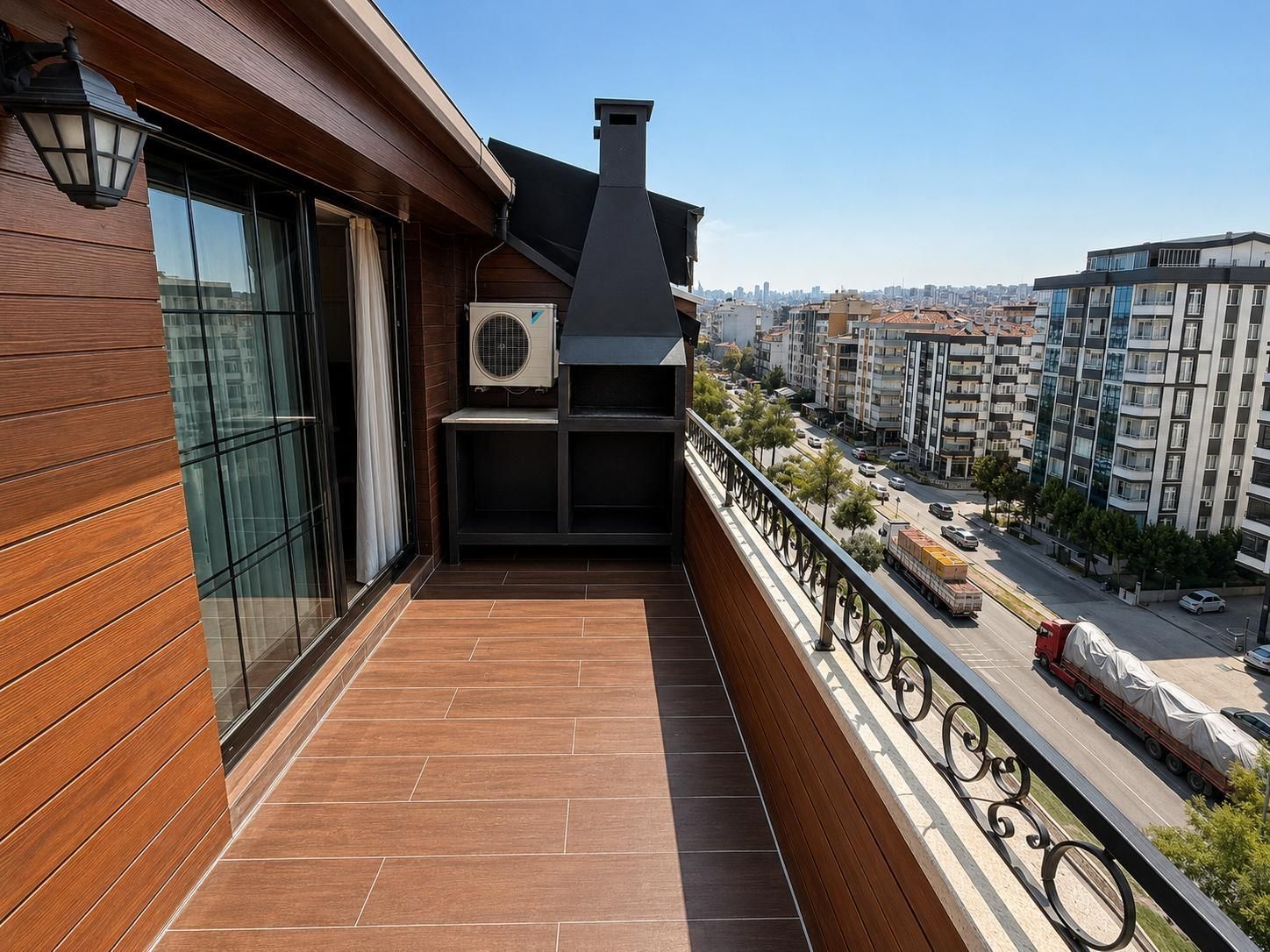 Ein Balkon mit Blick auf eine Stadtlandschaft, ein Fenster mit Vorhang und eine Klimaanlage.