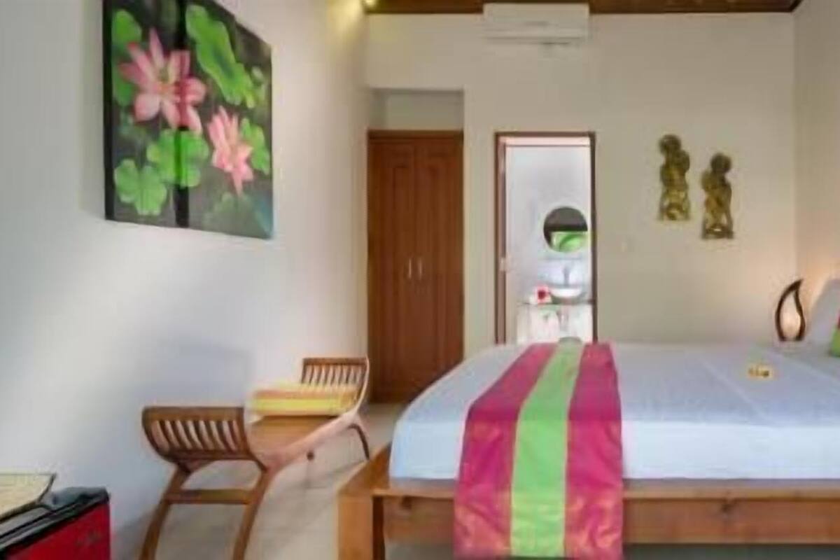 Une chambre à coucher avec un lit, une chaise, un bureau et un tableau.