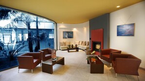 Een moderne woonkamer met een groot raam, een open haard en een zithoek.