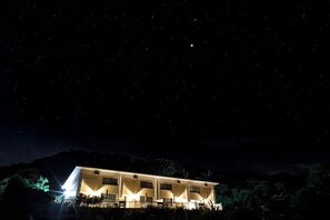 A modern building with multiple windows and a flat roof, surrounded by trees. - Forest West Nishi (Nakijin)