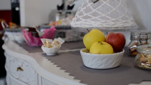 A kitchen counter with a bowl of fruit, a white decorative item, and a jar of nuts. - B&B Le Cupole di Trieste (Trieste)