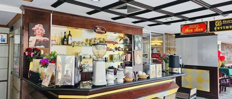 A bar area with a counter, stools, and various items on display.
