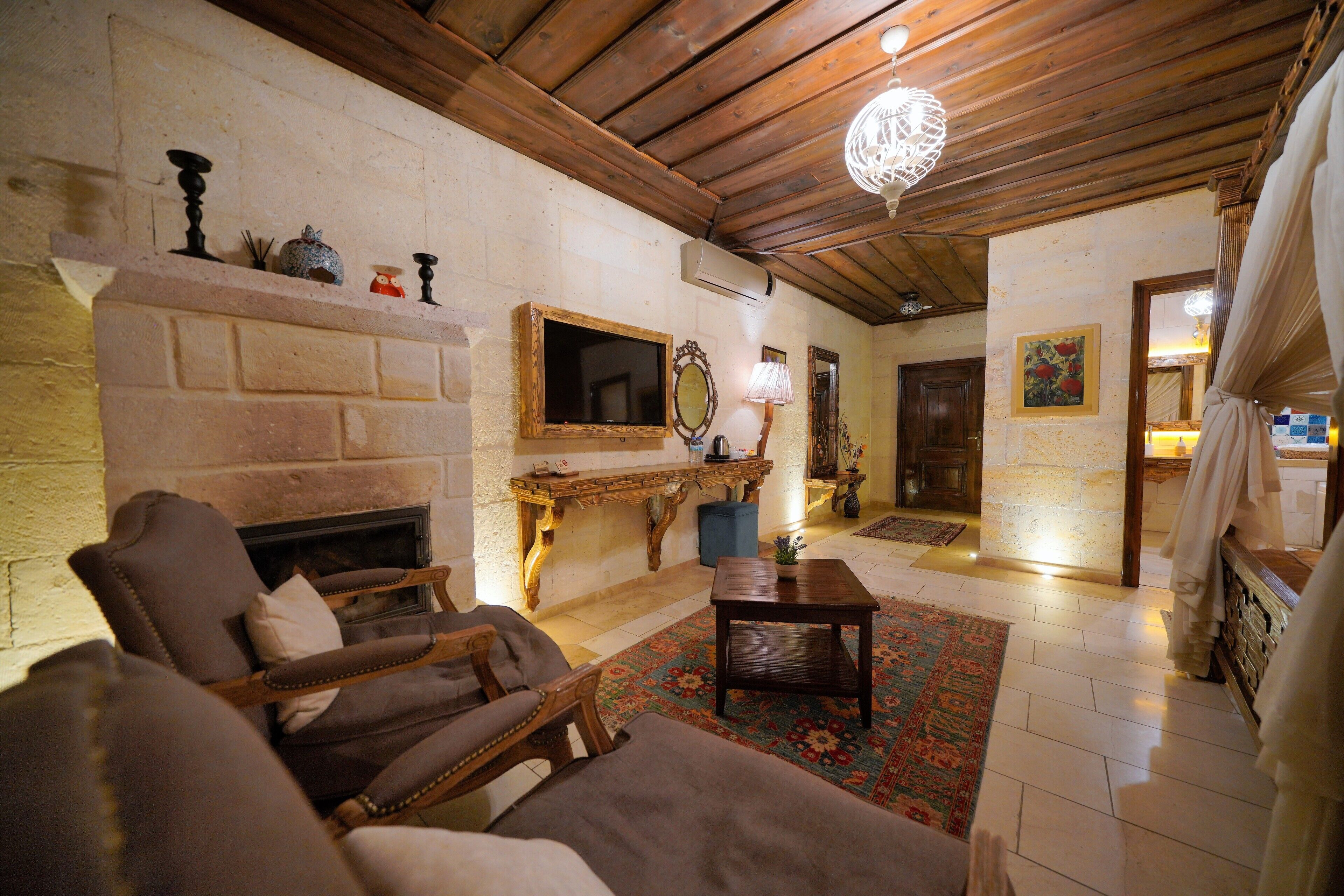 Una sala de estar acogedora con chimenea, muebles de madera y un espejo decorativo.
