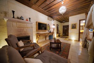 Una sala de estar acogedora con chimenea, muebles de madera y un espejo decorativo.