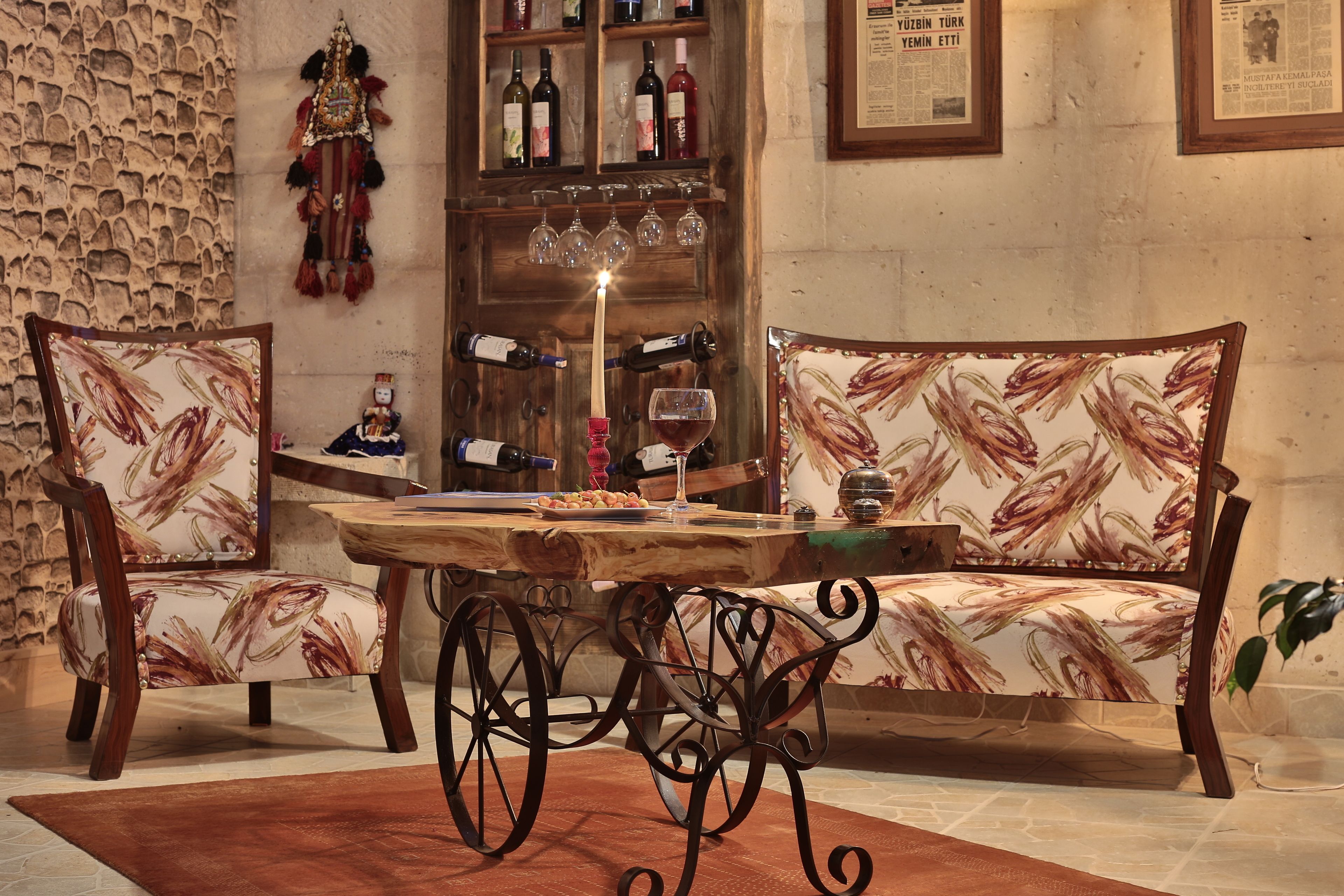 A cozy seating area with a wooden table, two upholstered chairs with a floral pattern, and a wine bottle on the table.