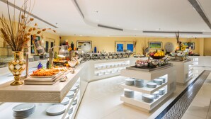 Montaje de bufé con diversos alimentos y un centro de mesa decorativo.
